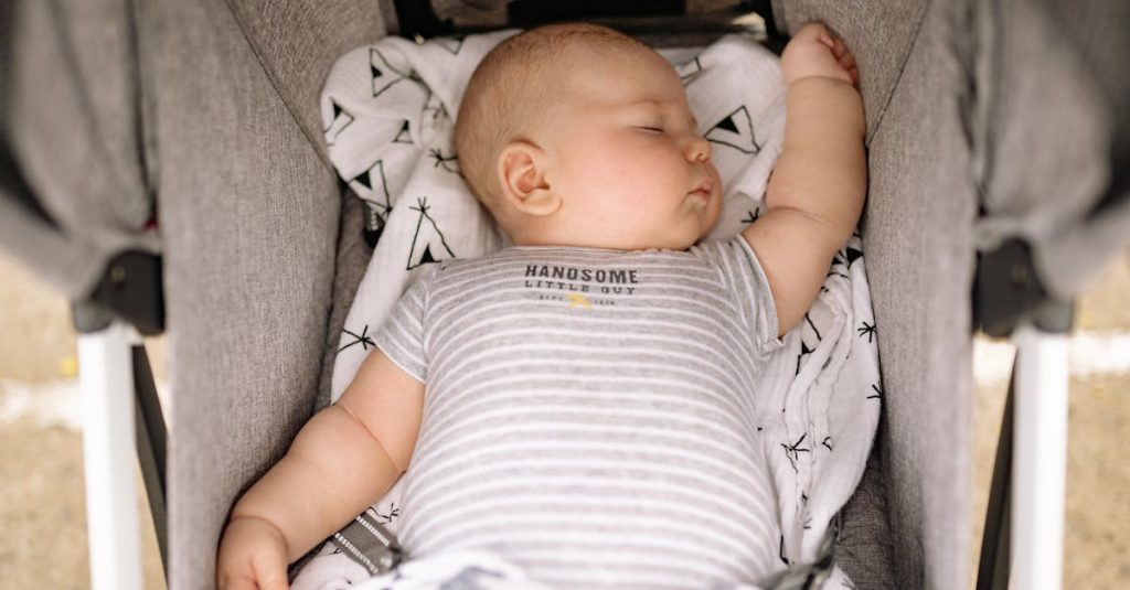 Adorable baby peacefully sleeping in a stroller, wearing a striped onesie.